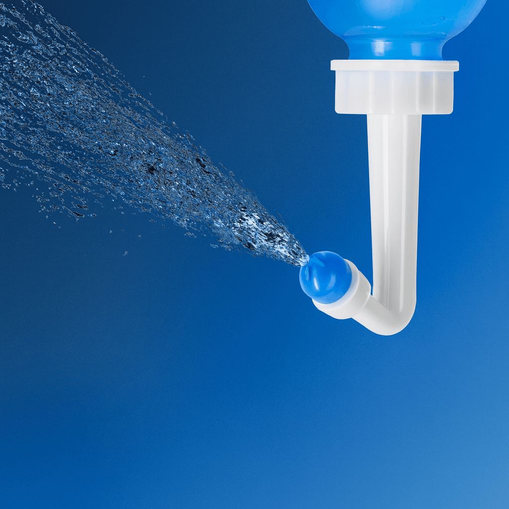 Demonstratie van de krachtige waterstraal die uit het opzetstuk van de neusspoeler komt tegen een donkerblauwe achtergrond.