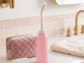 Bouteille bidet sur le lavabo à côté d'une trousse de toilette