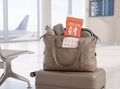 Pee bag in a travel bag on a suitcase in the departure hall