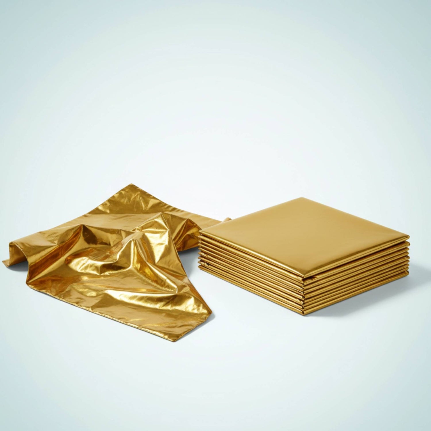 Gouden Comformidable isolatiedeken naast een stapel gevouwen dekens voor hittebescherming.